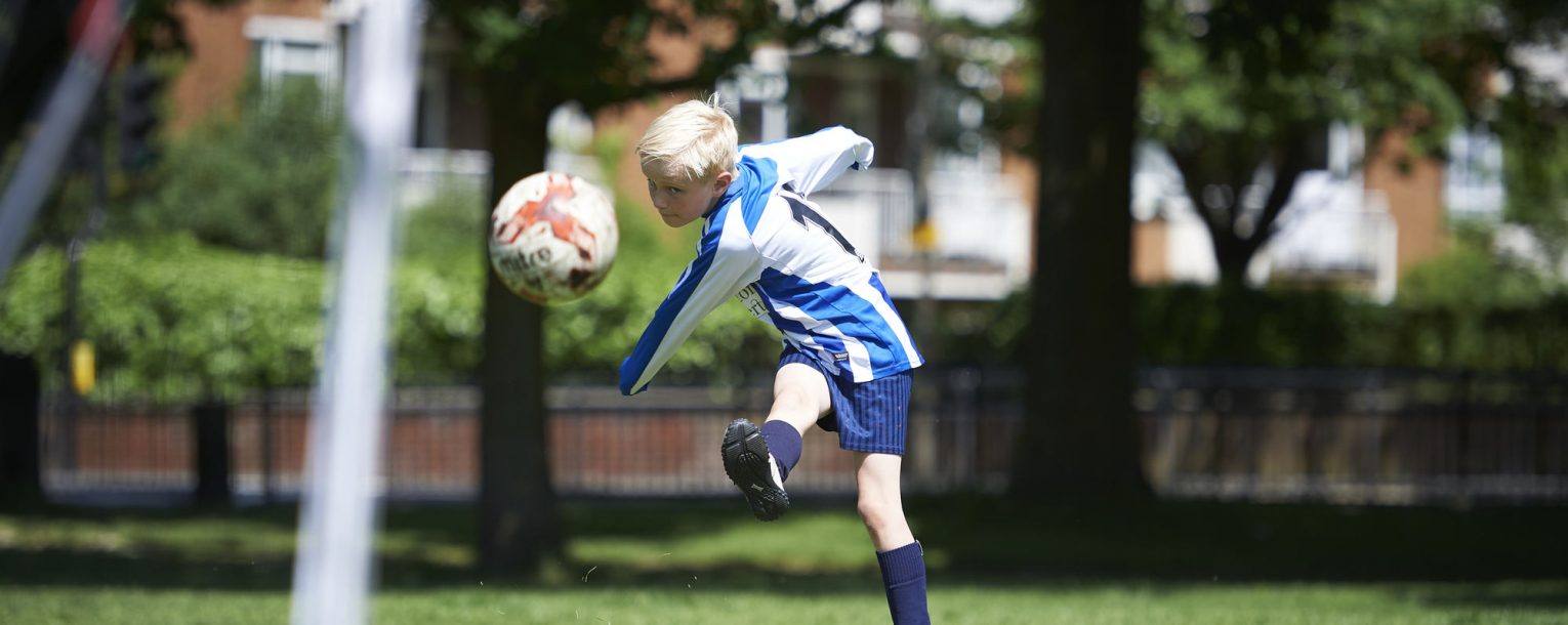 boy kicking football