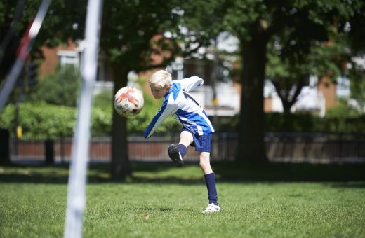 boy kicking football
